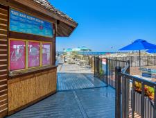 Enjoy food and drink at the Tiki bar just steps off the sand